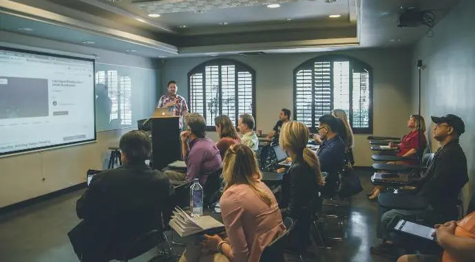 a group of people in a room with a projector screen
